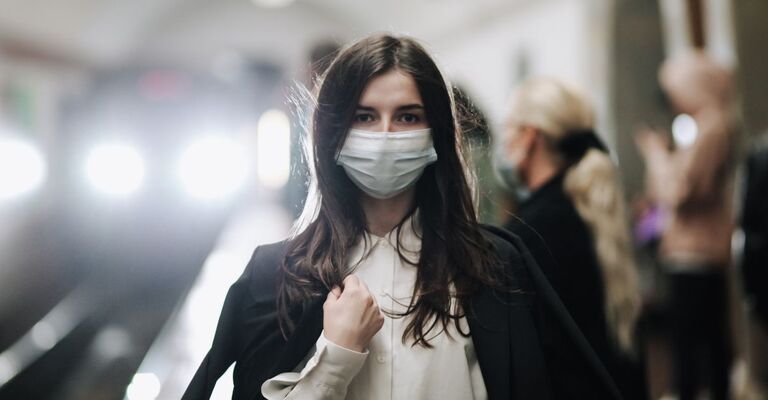 Una donna in metropolitana con la mascherina