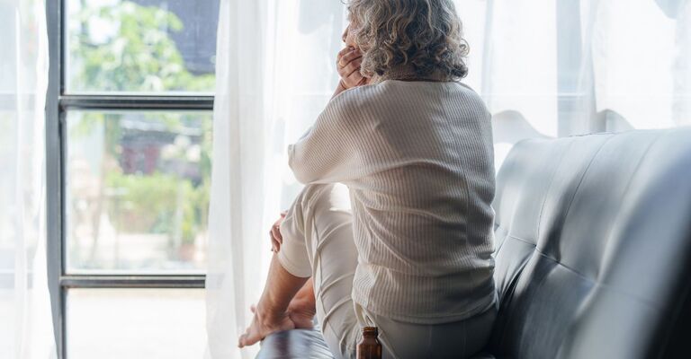 donna sola e triste sul divano