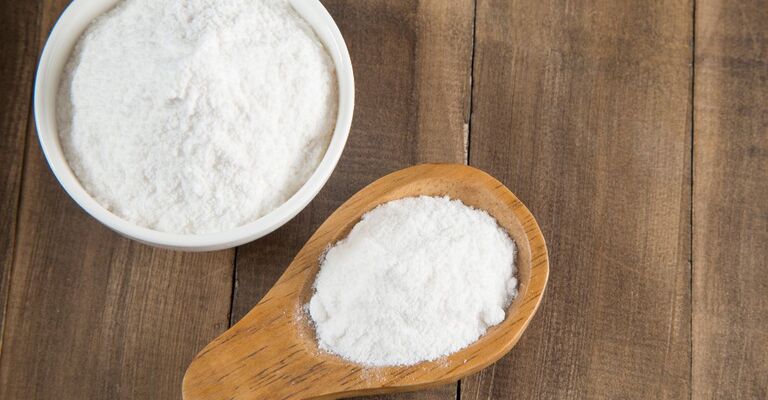 bicarbonato in un cucchiaio di legno e in una tazza