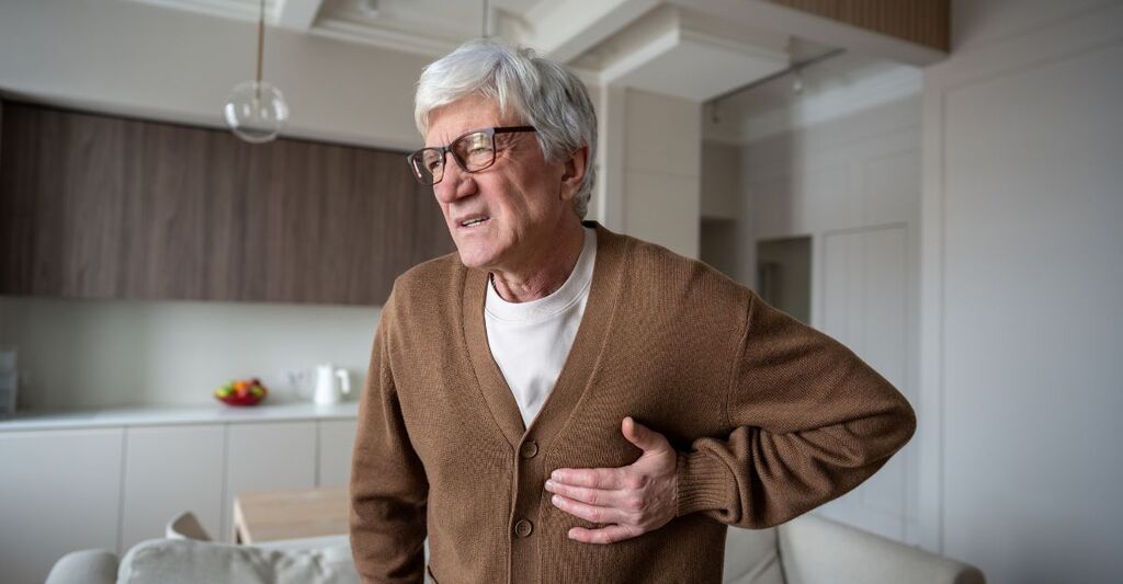 Un signore anziano si tiene il petto dolorante come se venisse colpito da un infarto