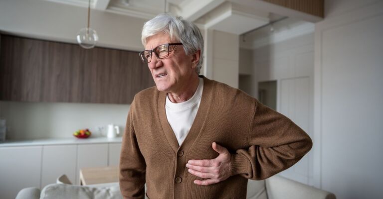 Un signore anziano si tiene il petto dolorante come se venisse colpito da un infarto