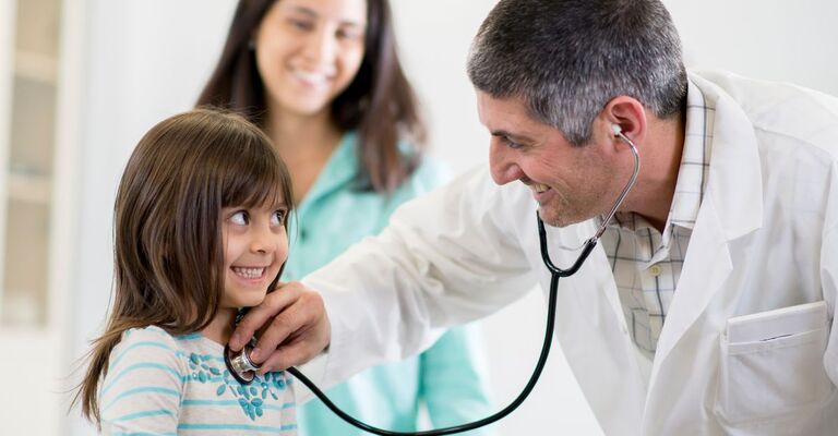 medico ausculta il cuore ad una bambina sorridente