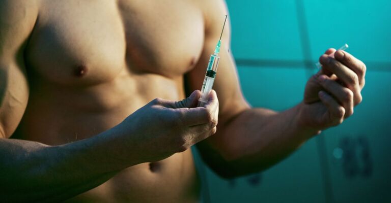 Uomo muscoloso tiene una siringa.