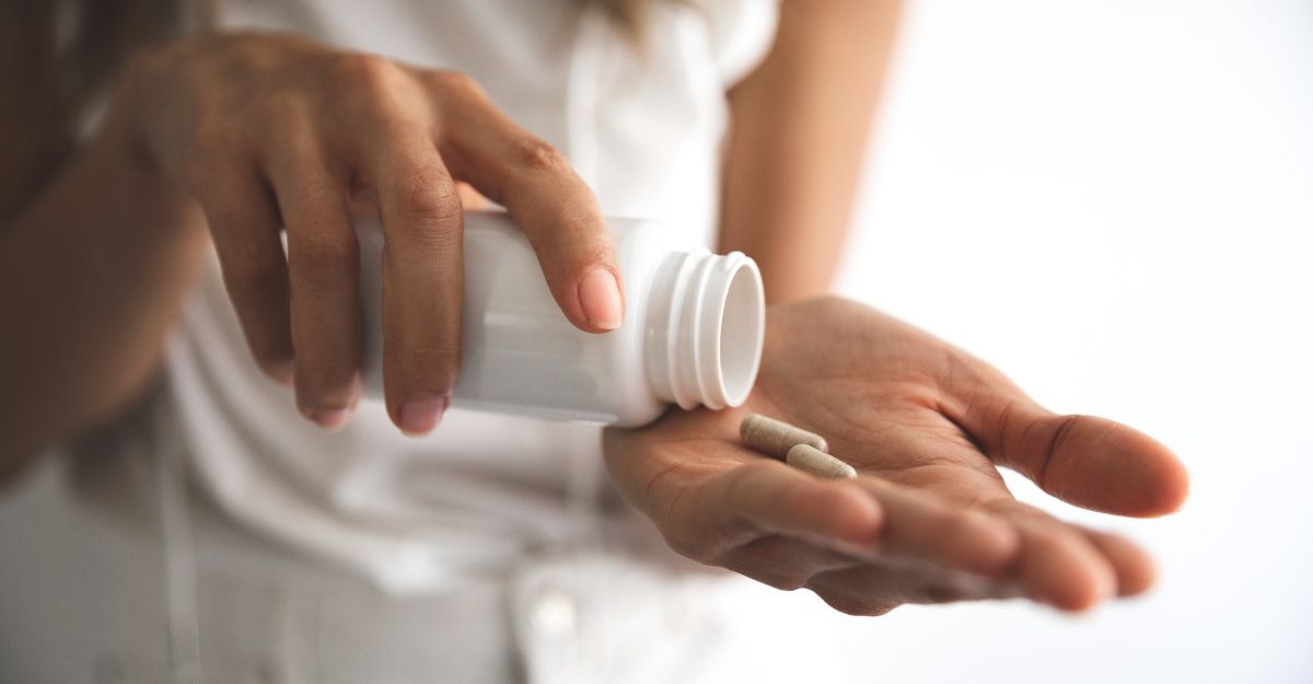 Donna versa pillole bianche sul palmo.