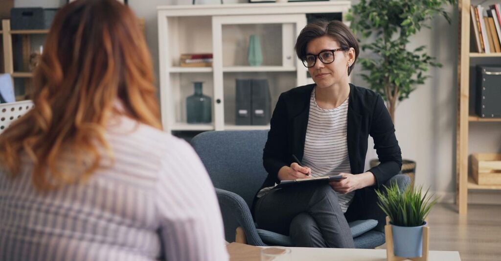 Una persona di spalle che parla con un medico