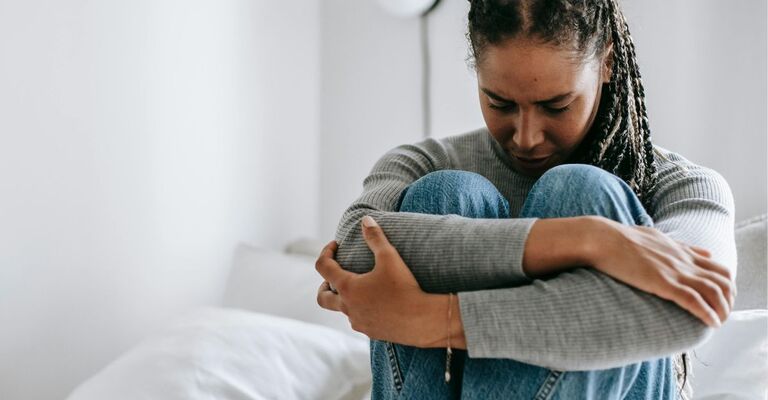 Ozempic® e un effetto collaterale poco noto donna preoccupata rannicchiata