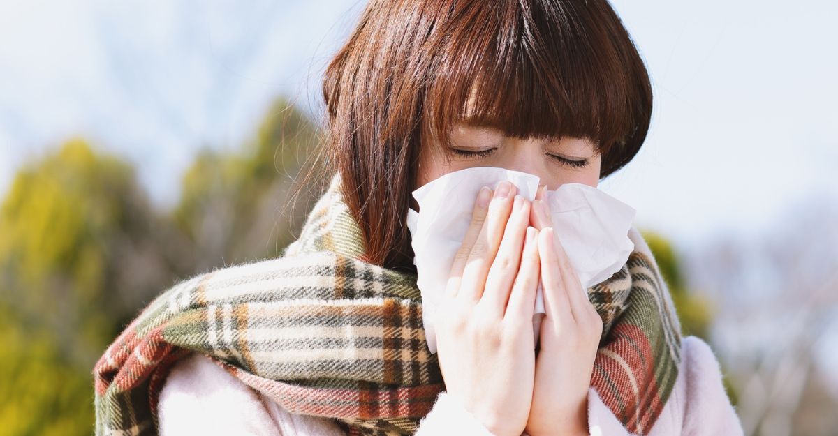 Donna che si soffia il naso in un fazzoletto all'aperto.