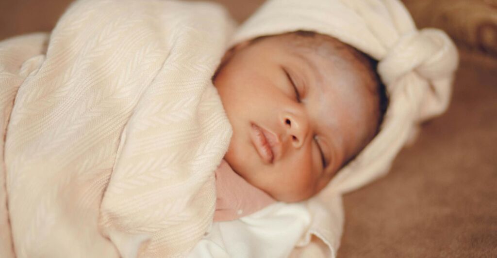 Un neonato avvolto nel sacco per la nanna.