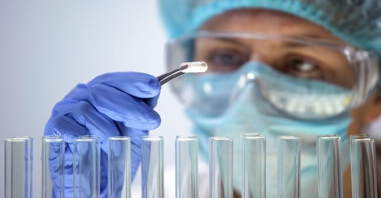 ricercatrice tiene inserisce molecola in alcune provette da laboratorio