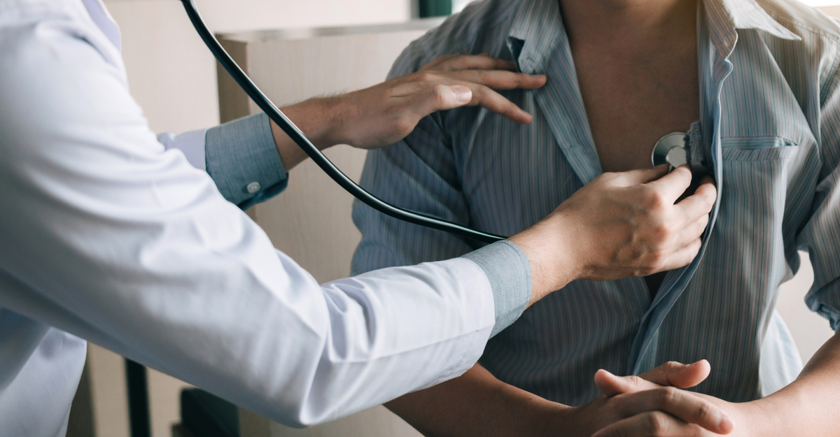 Un medico usa uno stetoscopio per auscultare il petto di un paziente.