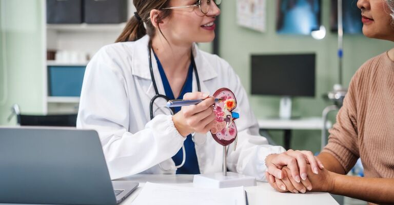 Una donna caucasica e un'anziana donna asiatica discutono di problemi renali come calcoli biliari, glomerulonefrite, malattia renale acuta/cronica, infezioni, ureteri anomali, cisti, cancro del sistema urinario