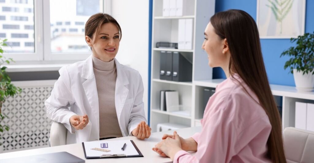 Ginecologa che parla con una paziente in studio