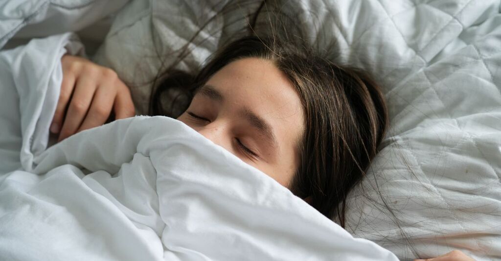 Una donna sotto le coperte mentre dorme.