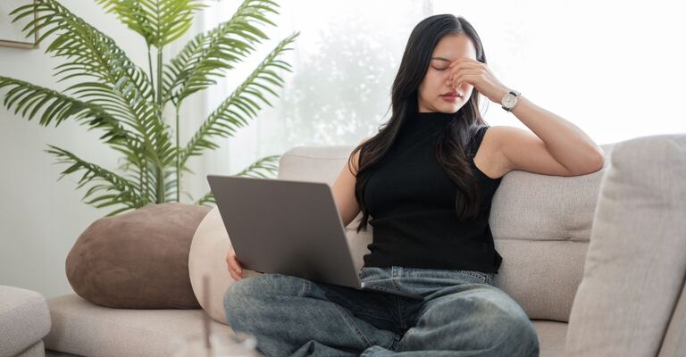 Una donna sul divano affetta da sindrome da fatica cronica.