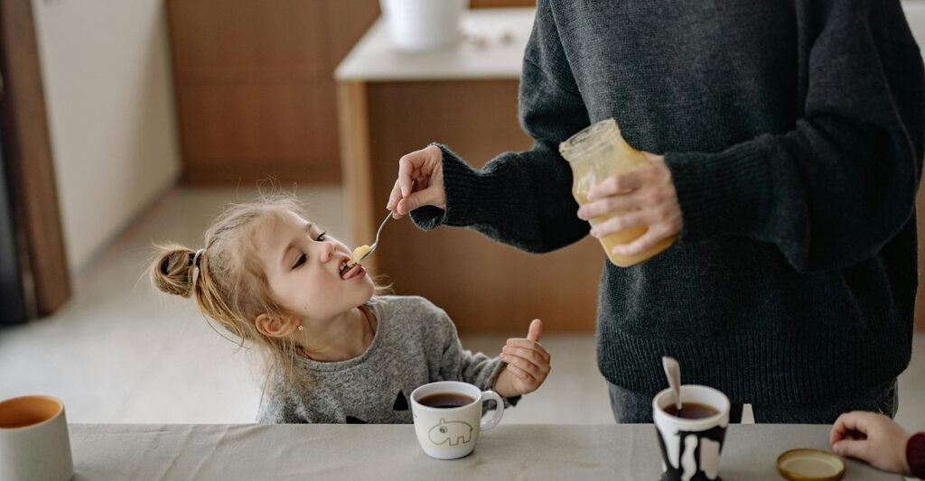 Un bambino che mangia il miele