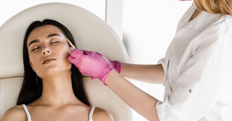 Un medico estetico pratica la procedura di biorivitalizzazione al contorno occhi di una paziente.
