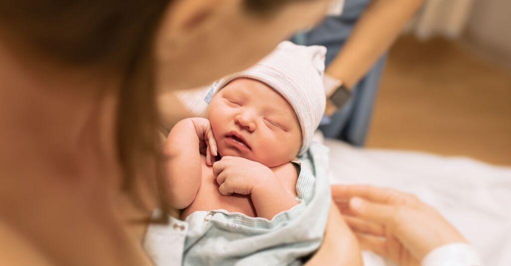 Una madre tiene in braccio un neonato