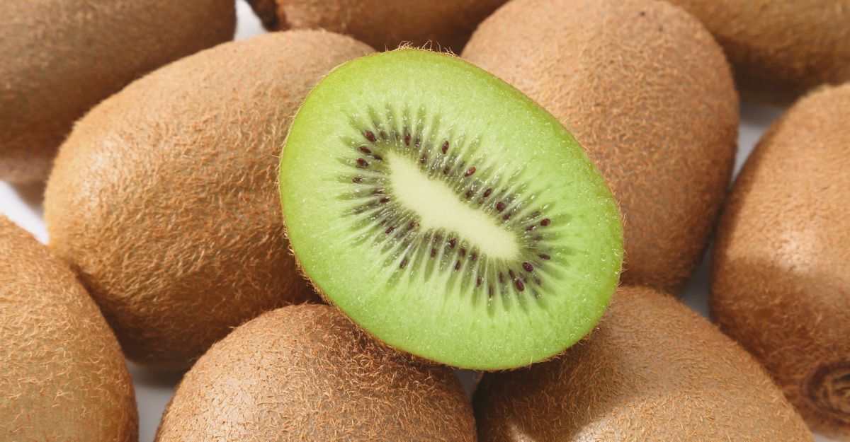 Sezione trasversale di un kiwi circondata da kiwi interi.