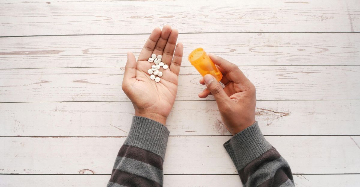 Mani con pastiglie di litio e flacone.