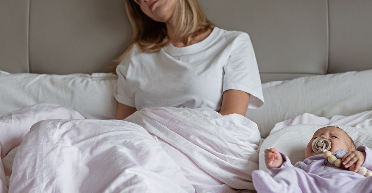 mamma stanca nel letto, con neonato che piange
