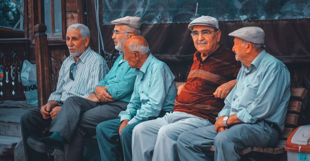 Alcuni uomini anziani seduti su una panchina.