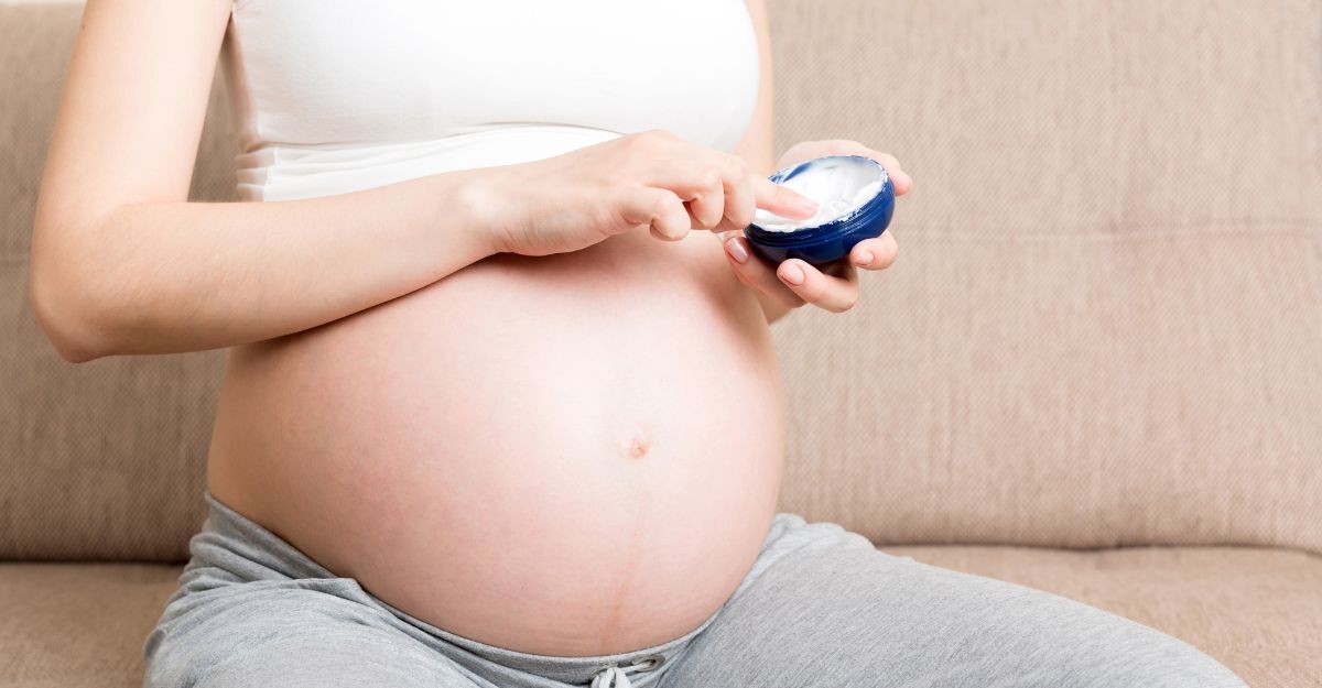 Crema anticellulite in gravidanza: guida sicura Una donna incinta mette la crema anticellulite.