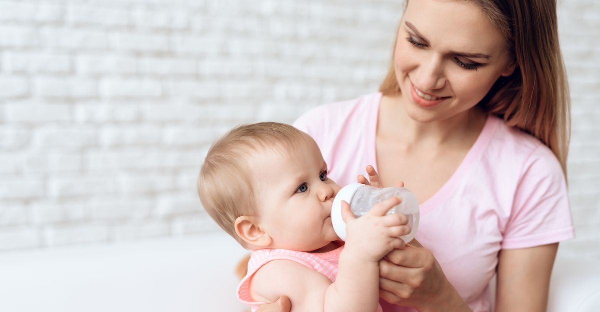 Una madre che tiene in braccio il neonato mentre usa il biberon