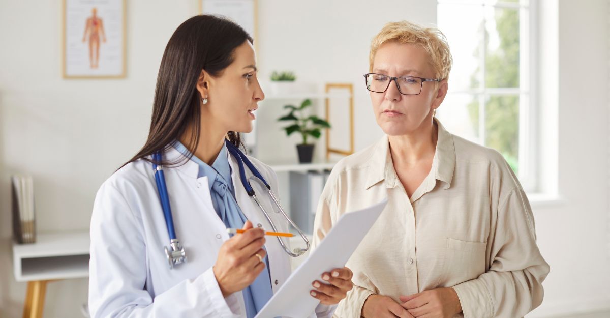 Demenza: studio rivela che il colesterolo basso riduce il rischio dell'80% Medico professionista in camice bianco discute i risultati degli esami medici con una paziente anziana in uno studio luminoso. Medico o cardiologo tiene in mano dei documenti e descrive il piano di trattamento alla donna adulta