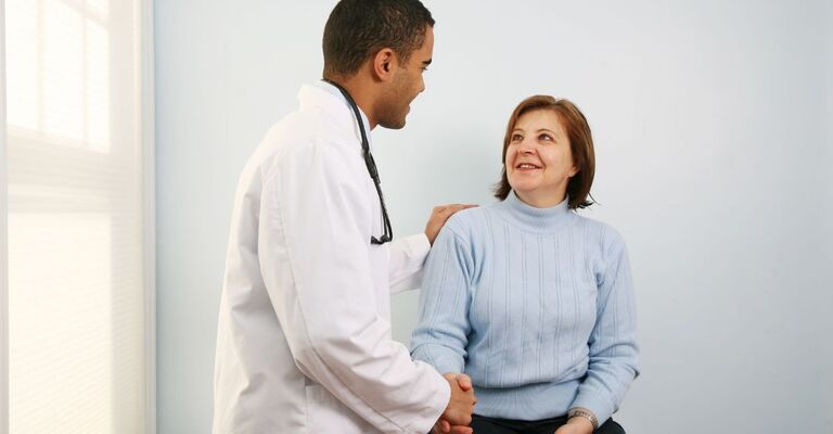 Pubblicati i nuovi LEA Medico in camice bianco parla con paziente donna seduta.