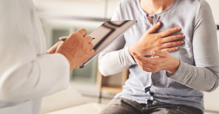Non sempre è perimenopausa quando i sintomi nascondono altro donna dal medico, si tocca il petto