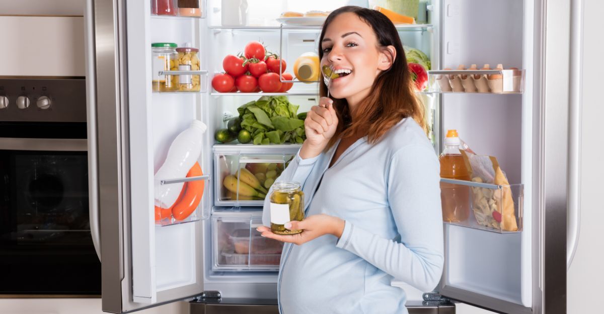 Una donna in gravidanza davanti al frigorifero.
