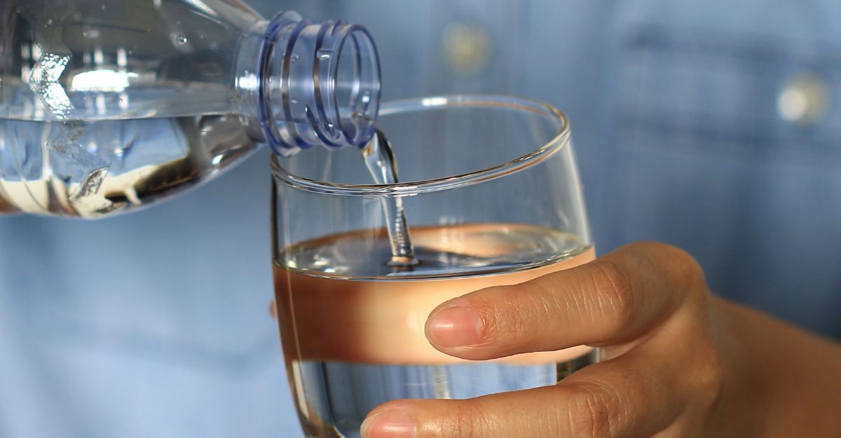 Bere poco cambia davvero il modo in cui il corpo reagisce allo stress mano tiene bicchiere di acqua