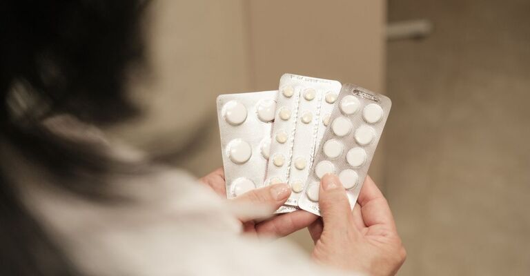 donna_che_tiene_diversi_flaconi_di_farmaci