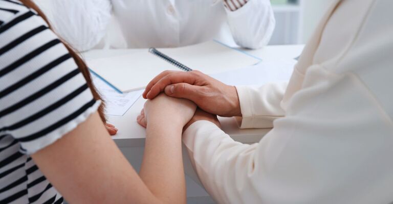 Primo piano di una coppia che si tiene la mano dal dottore