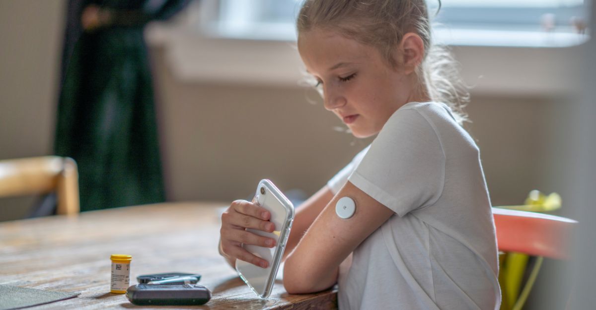 Ragazza con sensore di monitoraggio continuo della glicemia sul braccio.