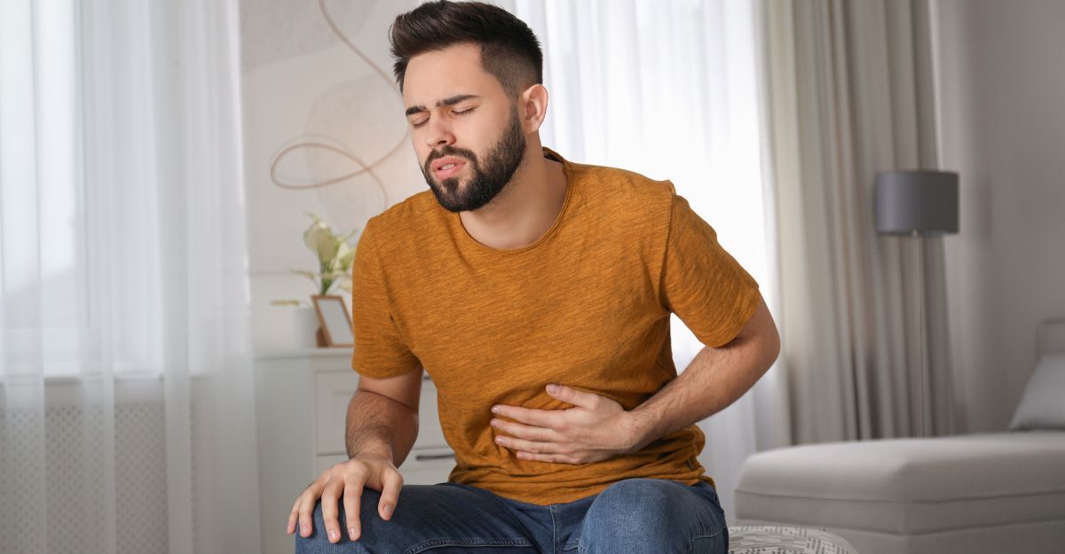 Un ragazzo che si tiene la pancia dolente