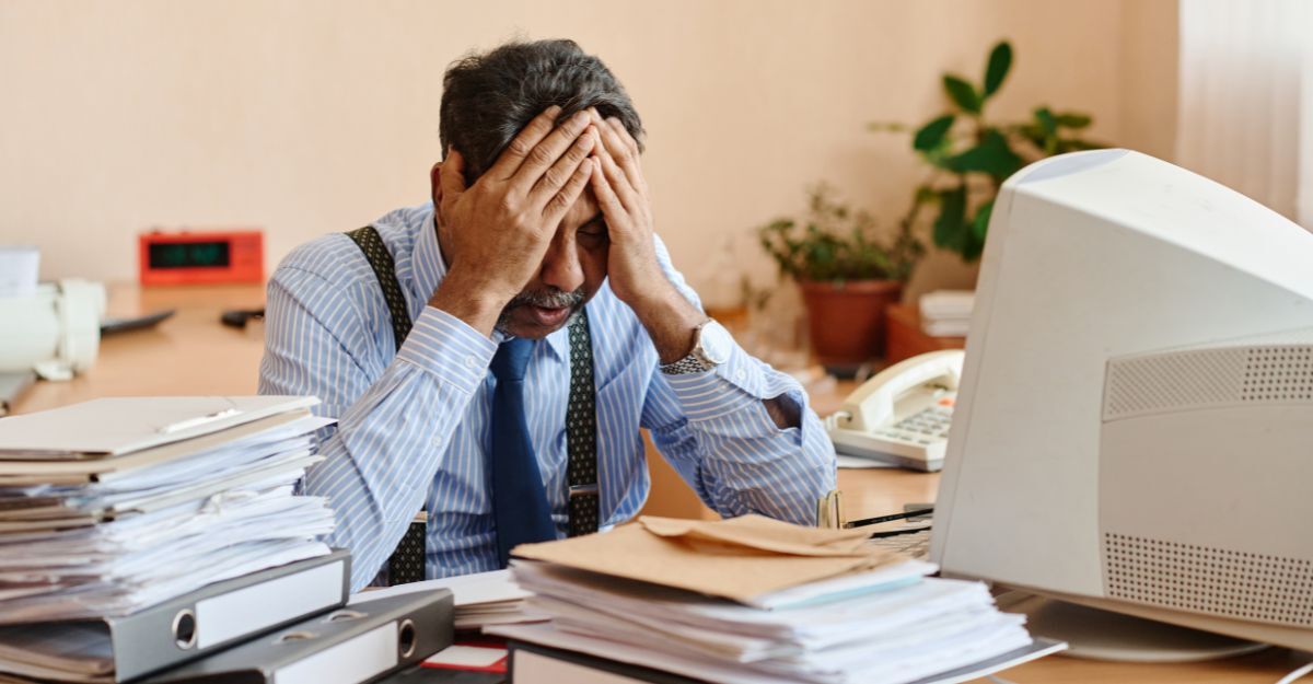 Un uomo stanco mentre lavora e cerca concentrazione.