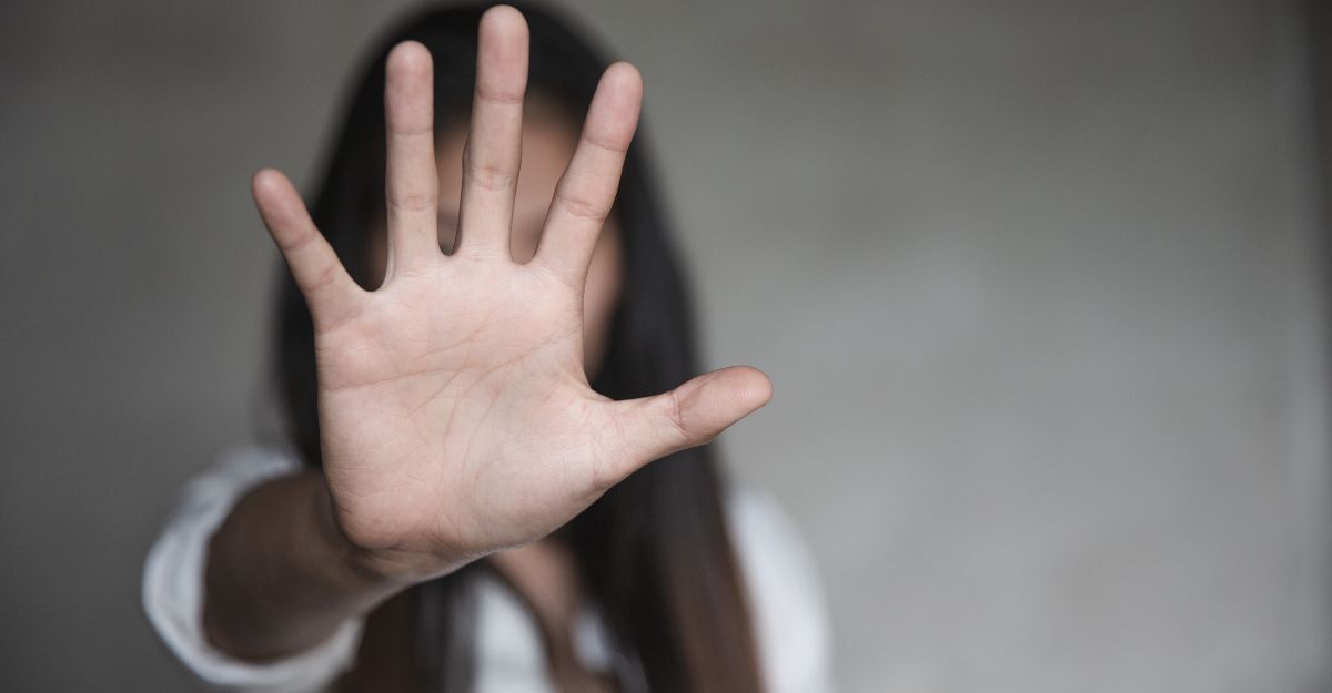 donna tiene una mano alzata, in segno di stop