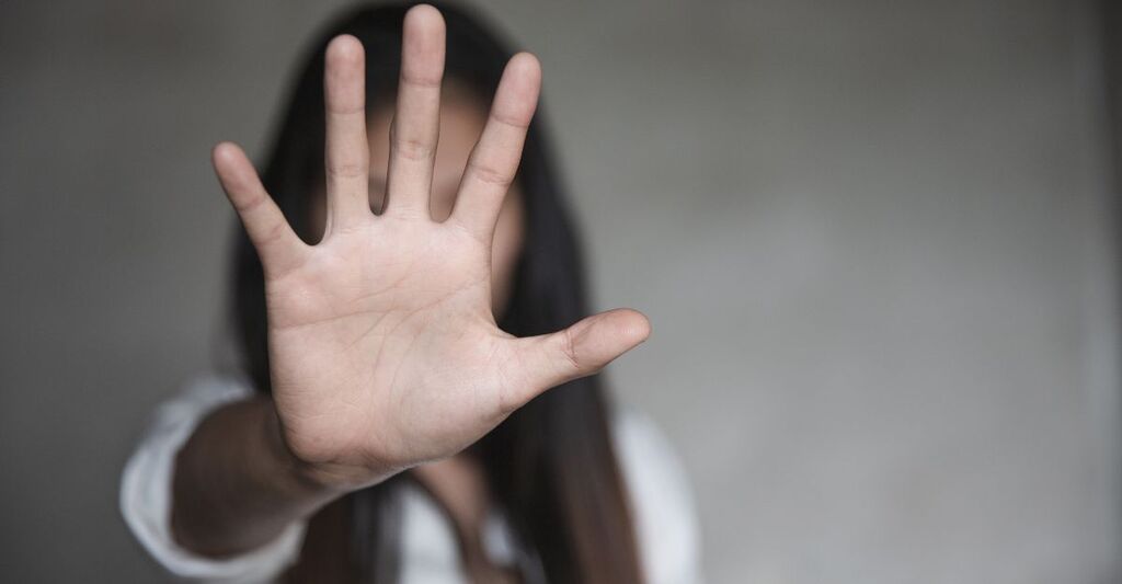 donna tiene una mano alzata, in segno di stop