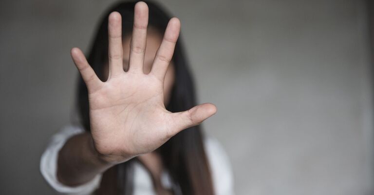 donna tiene una mano alzata, in segno di stop