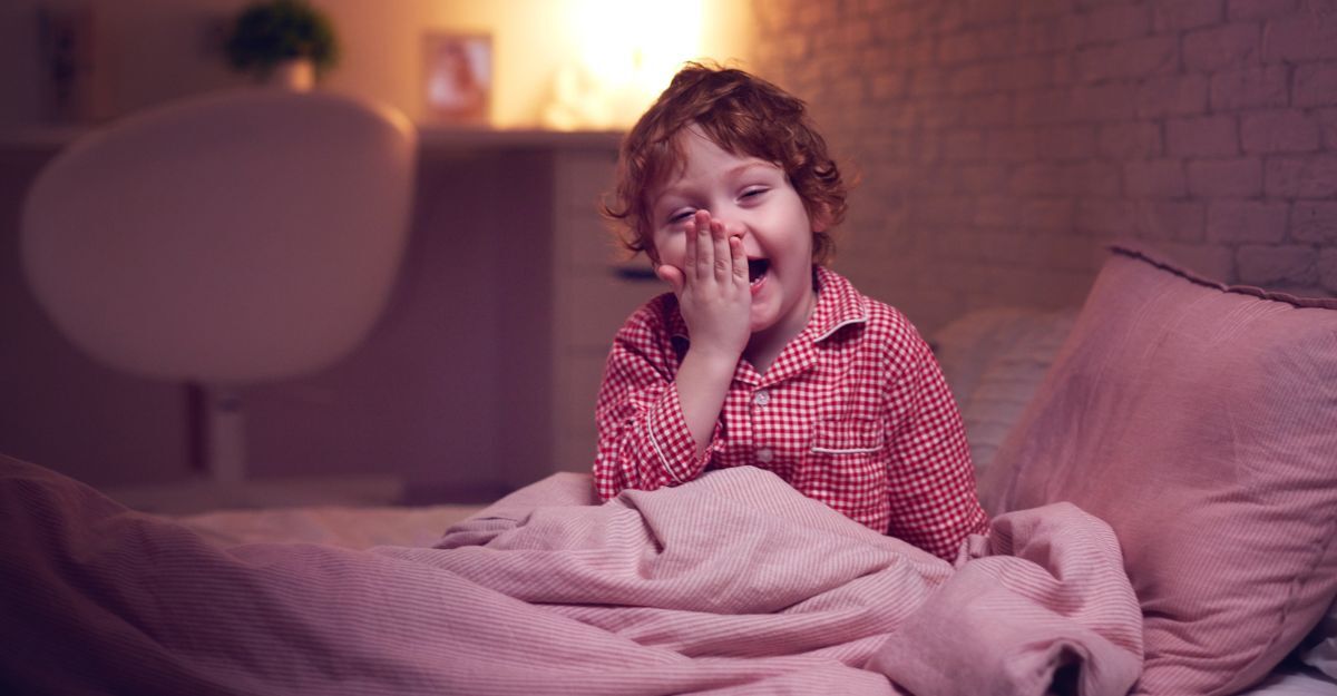 bimba seduta nel letto, sbadiglia