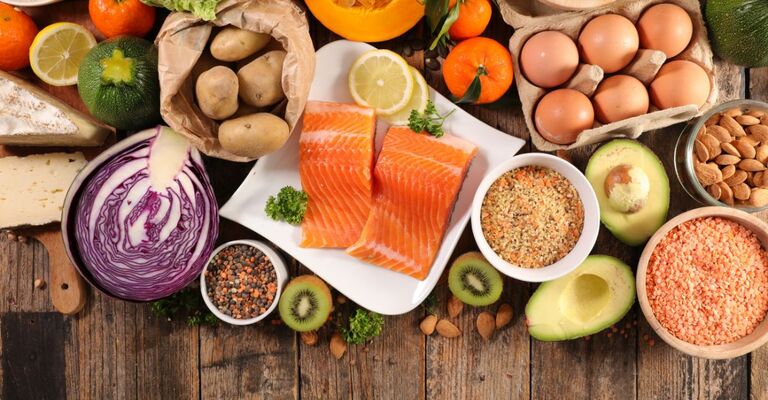 alimenti (salmone, uova , verdura, legumi) su un tavolo di legno