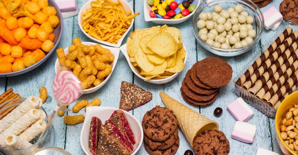 un tavolo colmo di cibo ultra-processato.