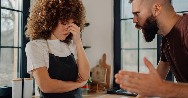 Coppia che litiga in cucina, donna frustrata che ascolta l'uomo che urla
