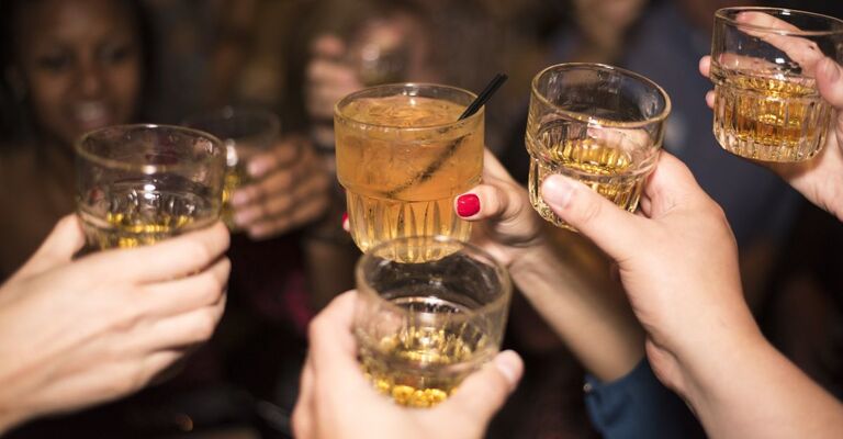 mani tengono bicchieri con super alcolico e fanno il brindisi