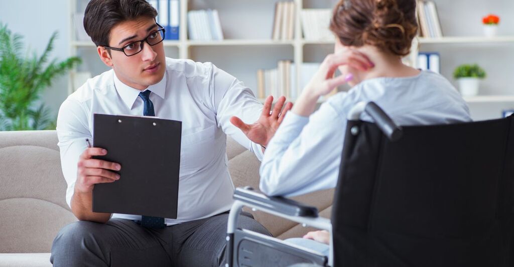 medico parla con paziente sulla sedia a rotelle