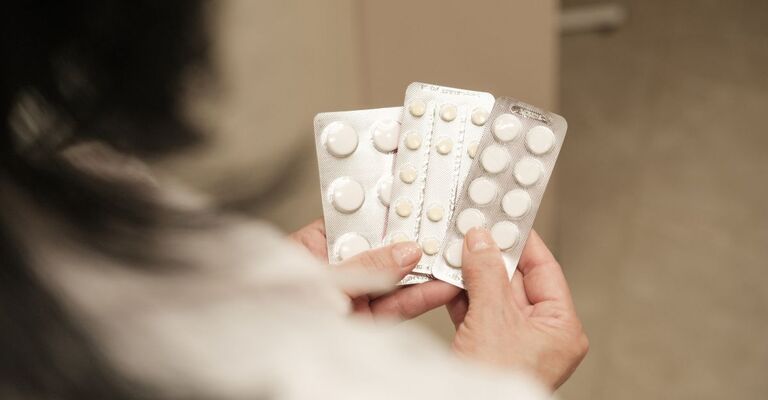 Una donna con in mano delle pillole per l'asma grave.