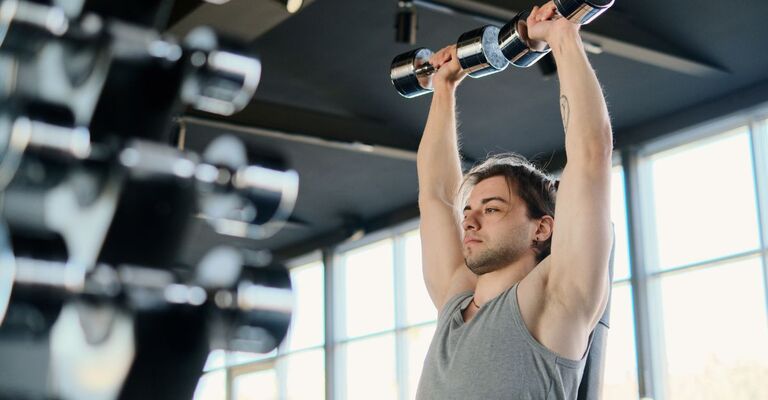 Un ragazzo pratica esercizio fisico con i pesi.