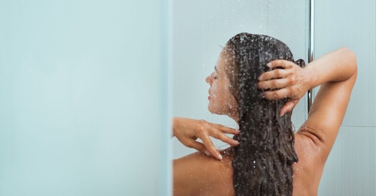 Una donna fa una doccia calda in inverno.