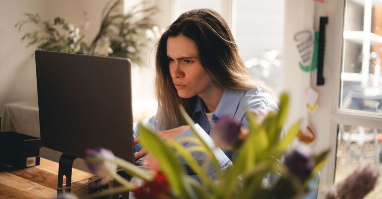 Una donna frustrata e infastidita è confusa per le cattive notizie online o per un video disgustoso sul web, un libero professionista stressato guarda un PC rotto